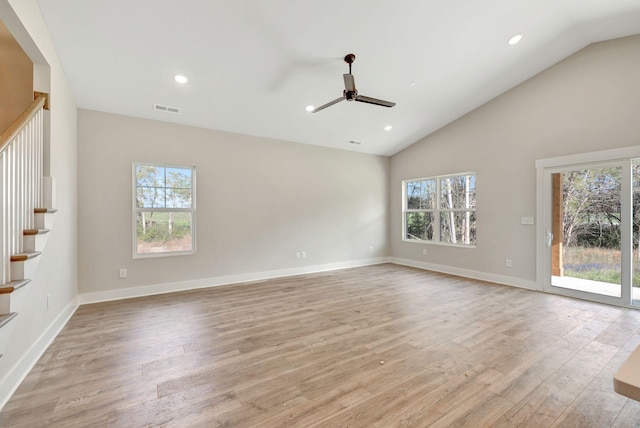 empty room with light wood finished floors, stairway, plenty of natural light, and visible vents