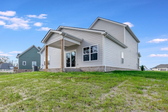 back of house featuring cooling unit and a yard