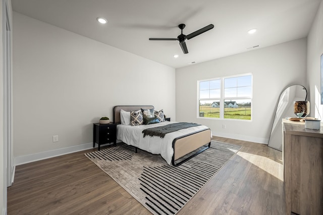 bedroom with baseboards, visible vents, and wood finished floors