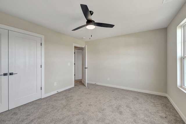 unfurnished bedroom with ceiling fan, multiple windows, baseboards, and carpet flooring