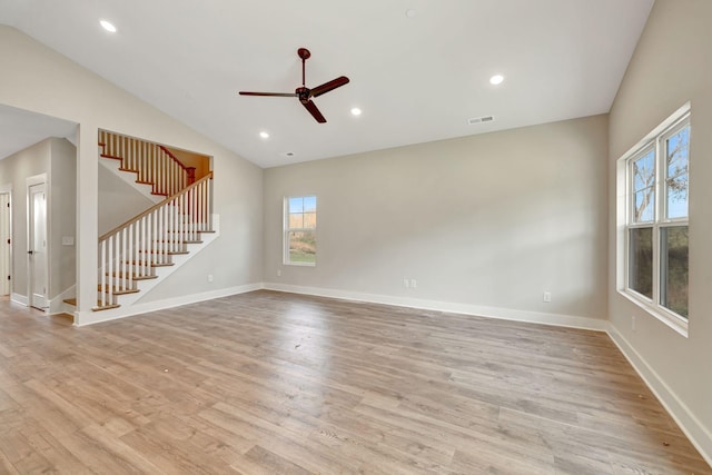 spare room featuring light wood-type flooring, visible vents, baseboards, and stairs