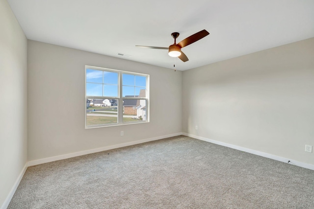 spare room featuring a ceiling fan, carpet, and baseboards