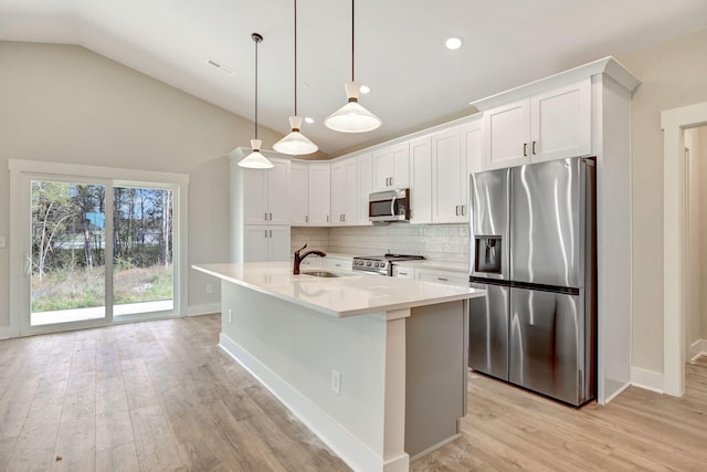 kitchen with stainless steel appliances, tasteful backsplash, light countertops, light wood-style floors, and vaulted ceiling