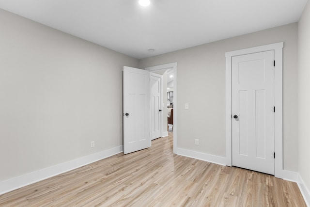 unfurnished bedroom featuring light wood-style floors and baseboards