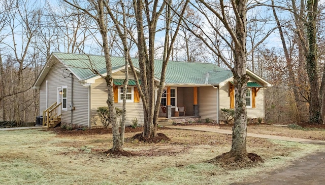 ranch-style house with metal roof, a porch, and central AC