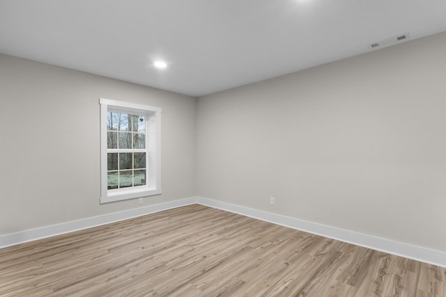 unfurnished room featuring light wood-type flooring, baseboards, visible vents, and recessed lighting