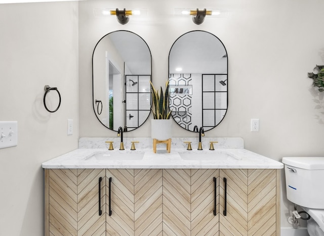 full bath featuring toilet, double vanity, and a sink