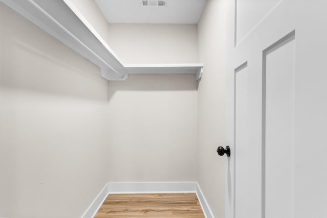 walk in closet with wood finished floors and visible vents