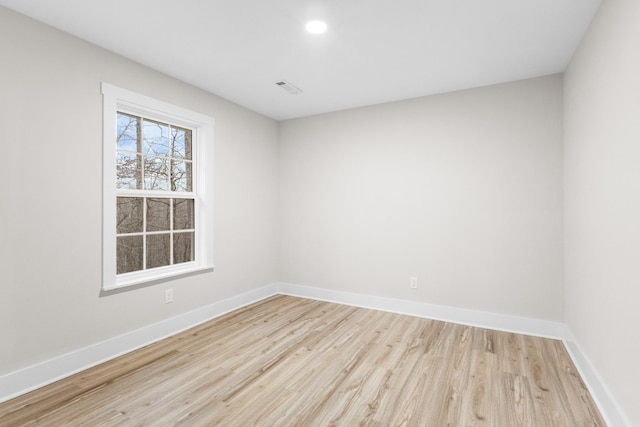 spare room with visible vents, baseboards, wood finished floors, and recessed lighting