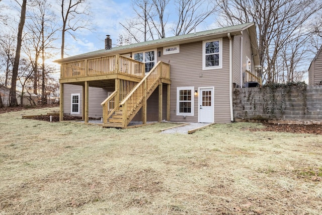 back of house featuring a yard, a chimney, fence, a deck, and stairs