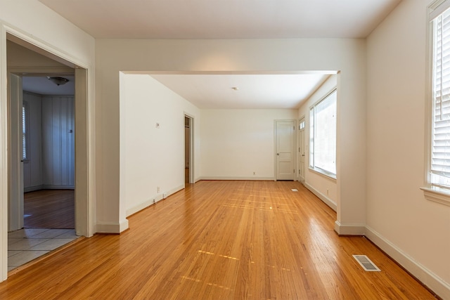 unfurnished room with baseboards, visible vents, and light wood-style floors