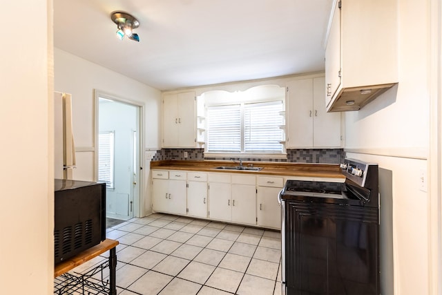 kitchen with a sink, decorative backsplash, electric stove, and light tile patterned flooring