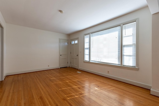 spare room with light wood-style flooring and baseboards