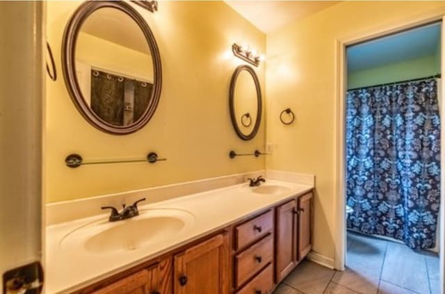 full bathroom featuring tile patterned floors, a sink, and double vanity