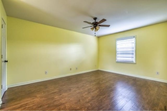 empty room featuring ceiling fan, wood finished floors, and baseboards