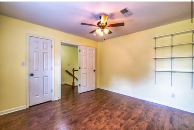 unfurnished bedroom with a ceiling fan, wood finished floors, visible vents, and baseboards