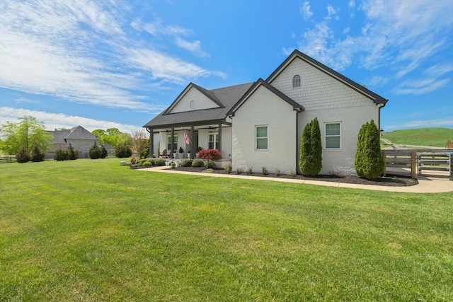 view of front facade featuring brick siding, fence, and a front yard