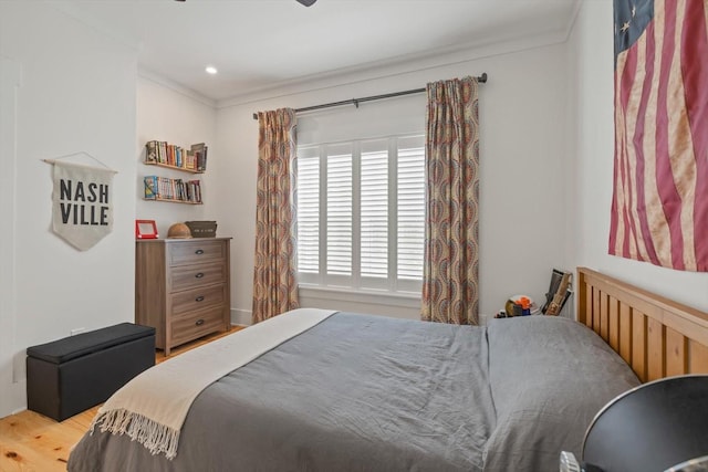 bedroom featuring wood finished floors and crown molding