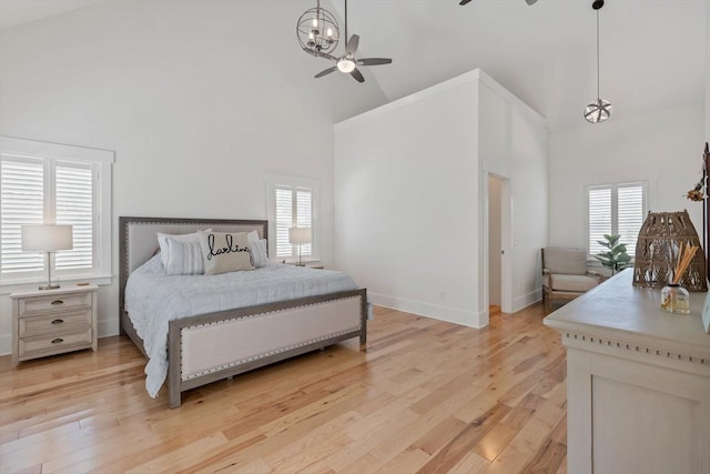 bedroom with light wood-style floors, multiple windows, and high vaulted ceiling