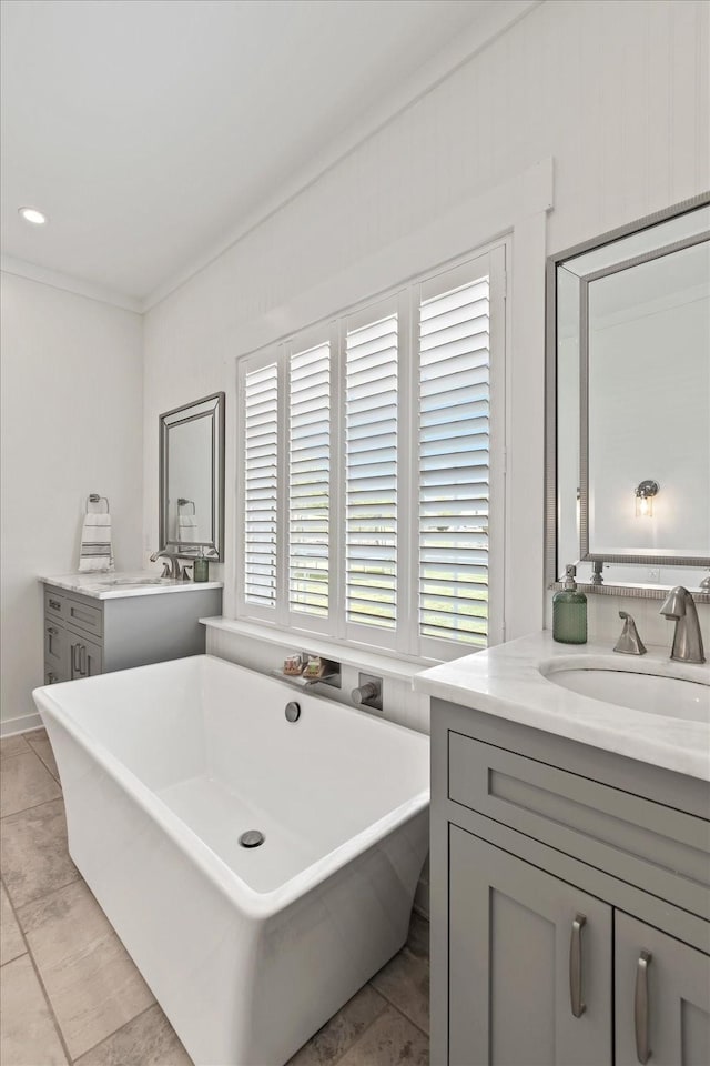 bathroom featuring crown molding, a freestanding bath, and vanity