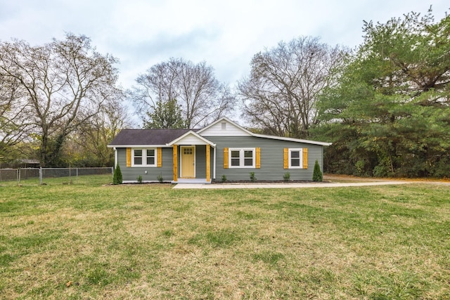 ranch-style home featuring fence and a front lawn