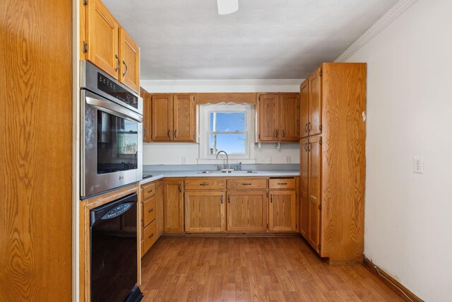 120 Wilkerson Ln, Portland, TN 37148 - kitchen with crown molding, light wood finished floors, light countertops, a sink, and oven