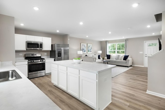 kitchen featuring a kitchen island, light countertops, recessed lighting, appliances with stainless steel finishes, and light wood-style floors