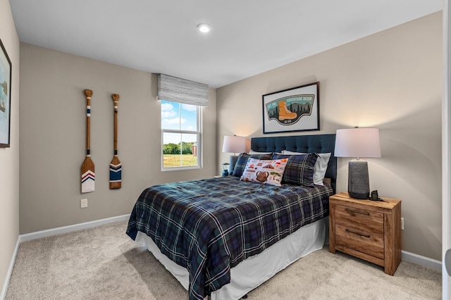 bedroom featuring light carpet and baseboards