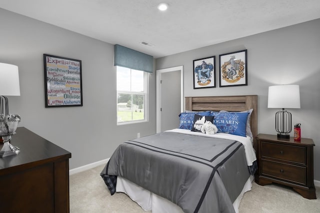 bedroom with visible vents, light colored carpet, and baseboards