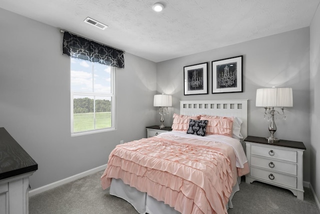 bedroom with carpet flooring, baseboards, visible vents, and a textured ceiling