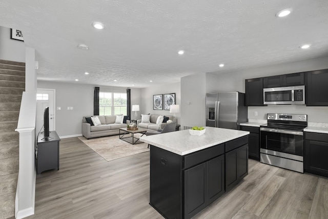 kitchen featuring appliances with stainless steel finishes, dark cabinets, and light countertops