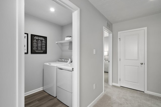 clothes washing area with laundry area, baseboards, visible vents, and washing machine and clothes dryer