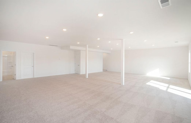 finished basement with light colored carpet, visible vents, and recessed lighting