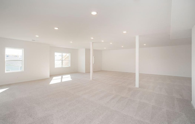 below grade area with light carpet and recessed lighting