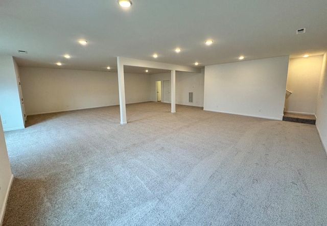 finished below grade area with recessed lighting, light carpet, visible vents, and baseboards