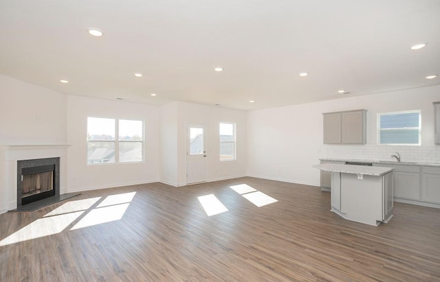 unfurnished living room with a fireplace, wood finished floors, and recessed lighting