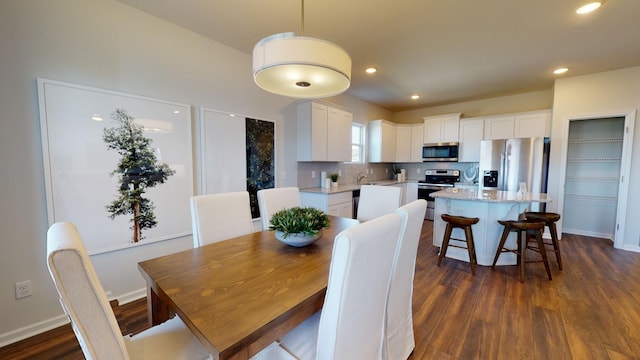 dining space with dark wood-style flooring, recessed lighting, and baseboards