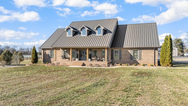 cape cod house with a standing seam roof, brick siding, and a front yard