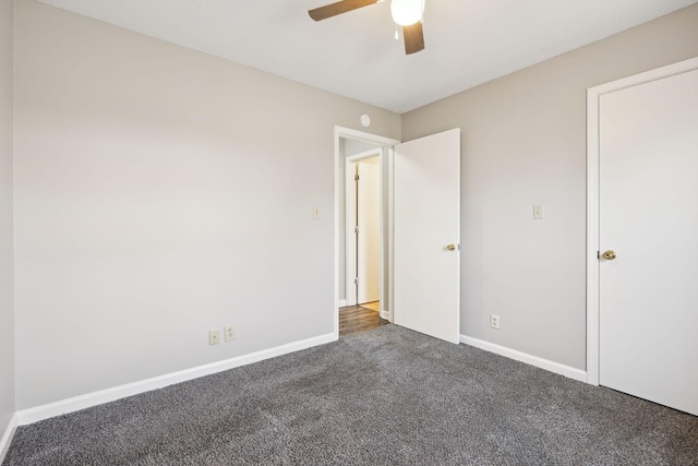 unfurnished bedroom with carpet flooring, a ceiling fan, and baseboards