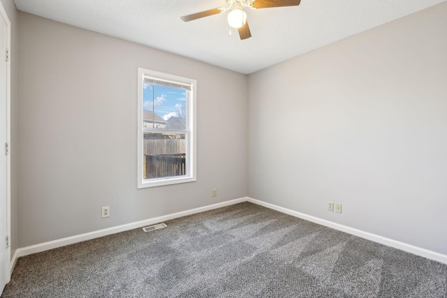 carpeted spare room with baseboards, visible vents, and a ceiling fan