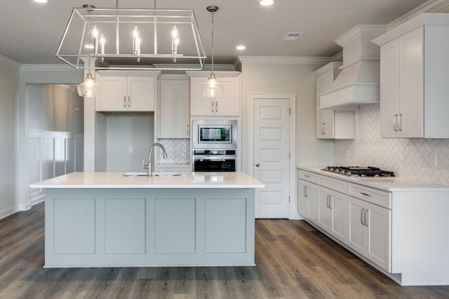 kitchen featuring premium range hood, a sink, visible vents, ornamental molding, and appliances with stainless steel finishes