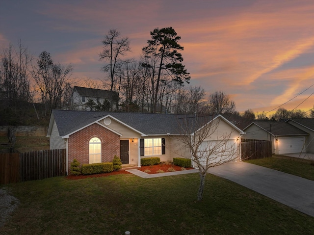 ranch-style home featuring driveway, an attached garage, fence, a yard, and brick siding