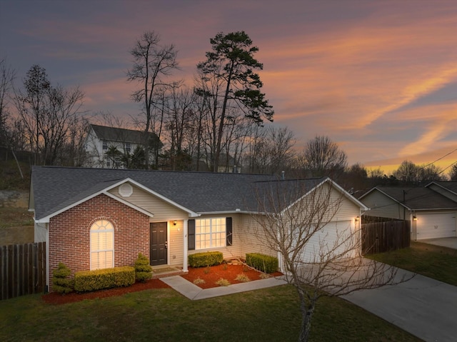 ranch-style house featuring brick siding, fence, a garage, driveway, and a front lawn