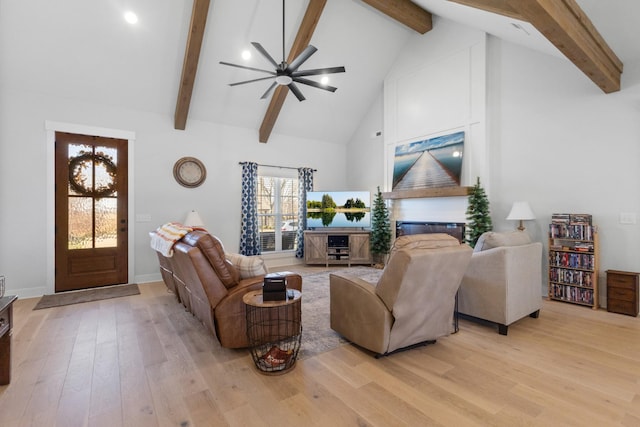 living area with light wood-style floors, a ceiling fan, high vaulted ceiling, and beam ceiling