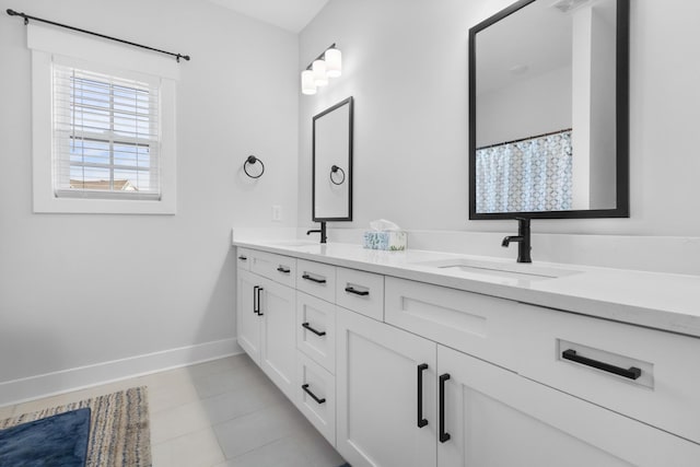 bathroom with double vanity, visible vents, baseboards, and a sink