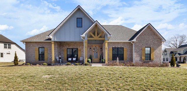 view of front of house with board and batten siding, brick siding, and a front lawn