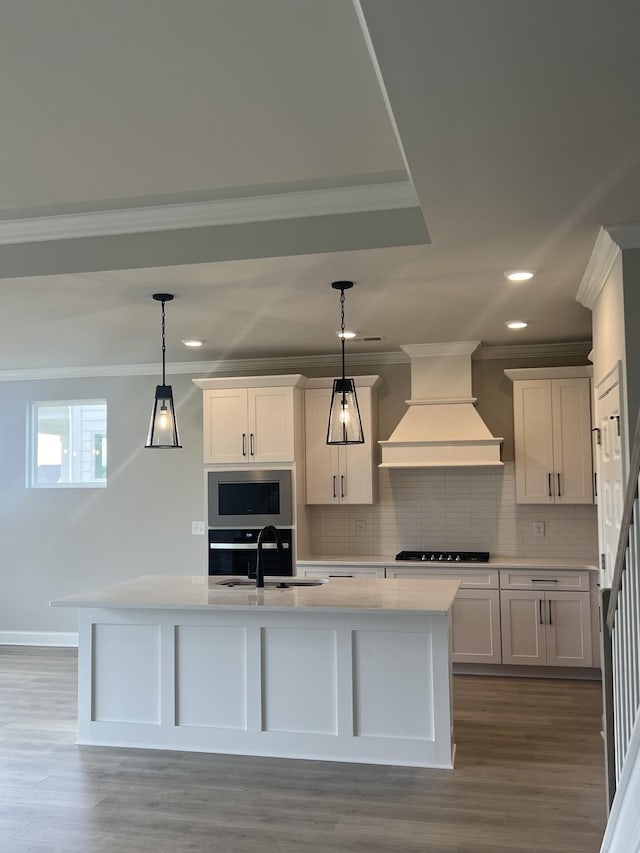 kitchen with crown molding, decorative backsplash, appliances with stainless steel finishes, a sink, and premium range hood