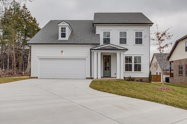 view of front of property with an attached garage, driveway, roof with shingles, and a front yard