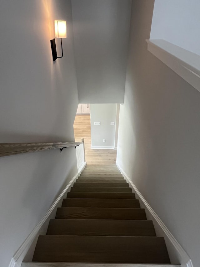 stairs featuring baseboards and wood finished floors