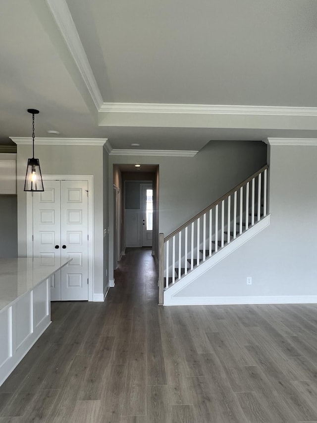 foyer entrance with stairs, dark wood-type flooring, crown molding, and baseboards